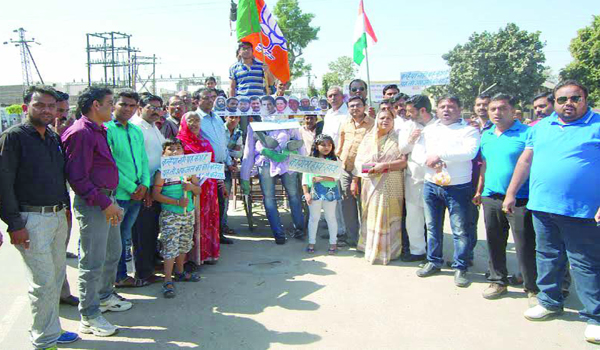 bjp office bearers and workers collected at ambedkar circle alongwith childerens holding plates in hand in sirohi.