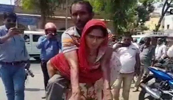 Woman Carries Handicapped Husband On Her Back To office to get a disability certificate