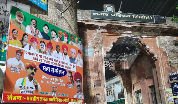 सिरोही के सरजावाव दरवाजे की दीवार पर वसुंधरा राजे के कार्यकाल में लगी हाईमास्ट लाईट में चमकता भारतीय किसान मोर्चा महासम्मेलन का होर्डिंग।